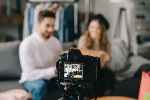 Two people filming themselves sitting in a couch for Instagram